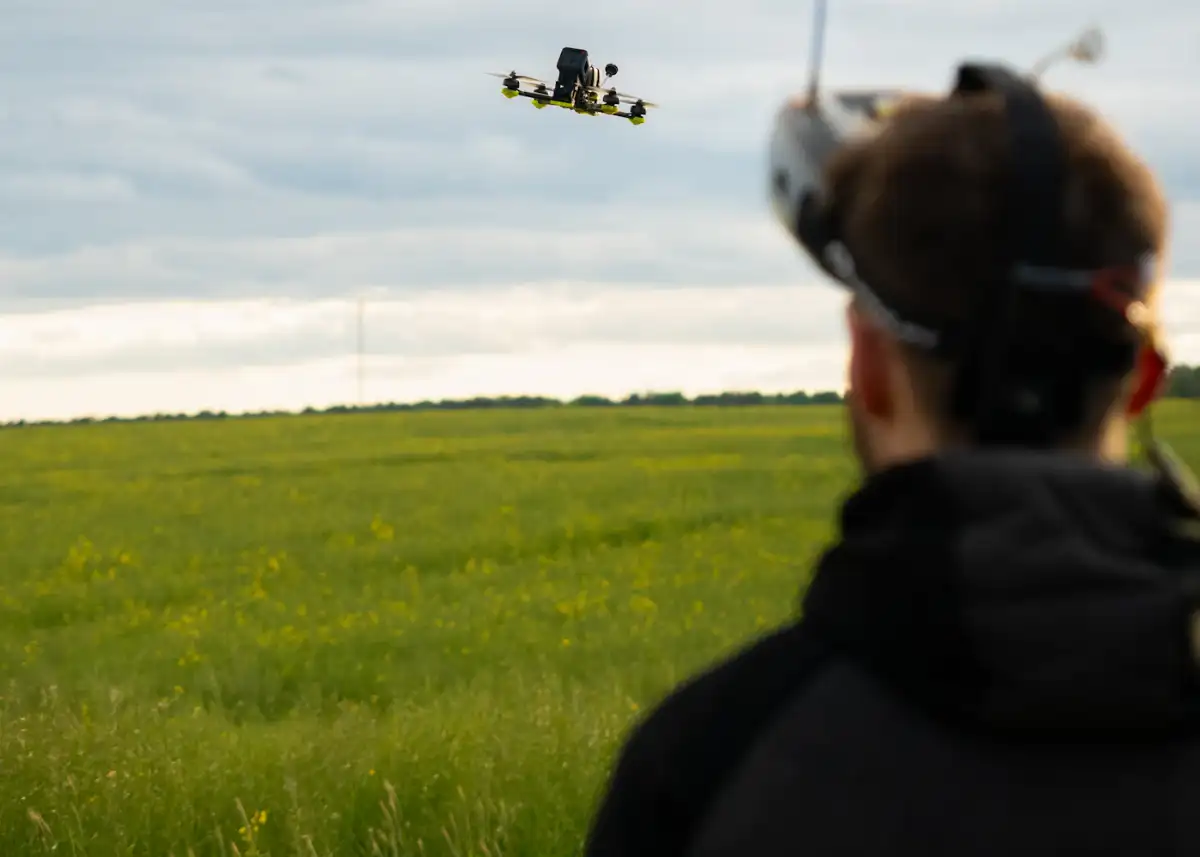 Técnico pilotando un dron sobre un cultivo